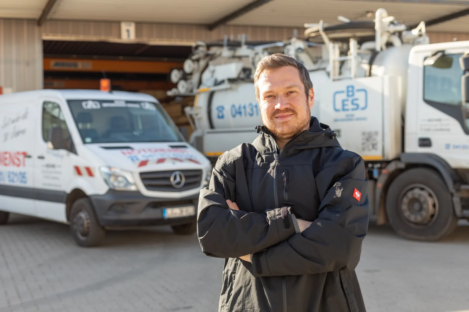 Marc Louis, Technischer Leiter der Behne Entsorgungs-Service GmbH, vor Saugwagen und Notdienstwagen auf dem Betriebshof in Lüneburg